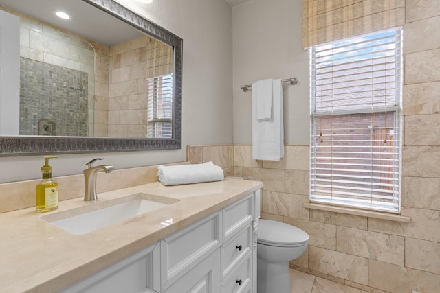 bathroom featuring tile walls, toilet, and vanity