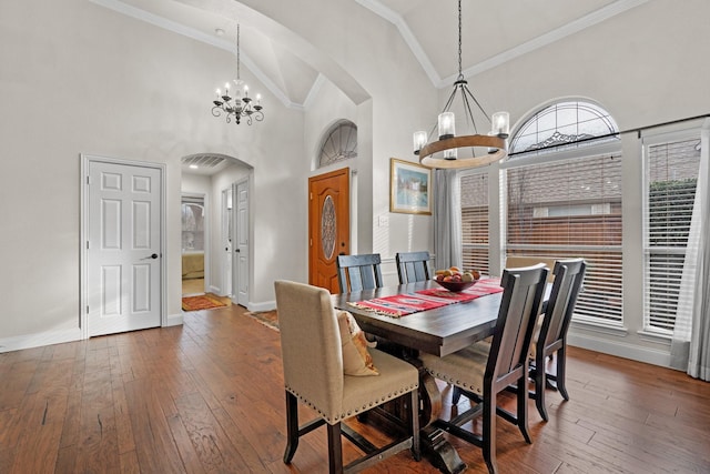 dining area featuring dark wood-type flooring, crown molding, high vaulted ceiling, and a notable chandelier