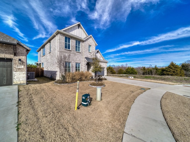 view of front of house with central air condition unit, a front lawn, and a garage