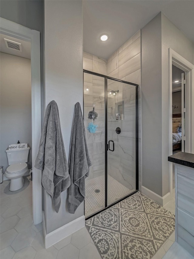 bathroom with toilet, walk in shower, and tile patterned floors