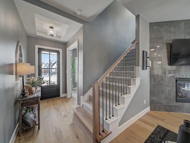 foyer entrance featuring light hardwood / wood-style floors and a tray ceiling