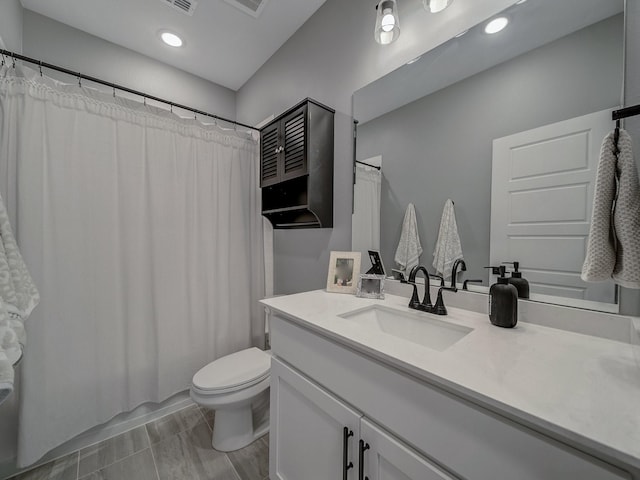 full bathroom with shower / tub combo with curtain, vanity, and toilet