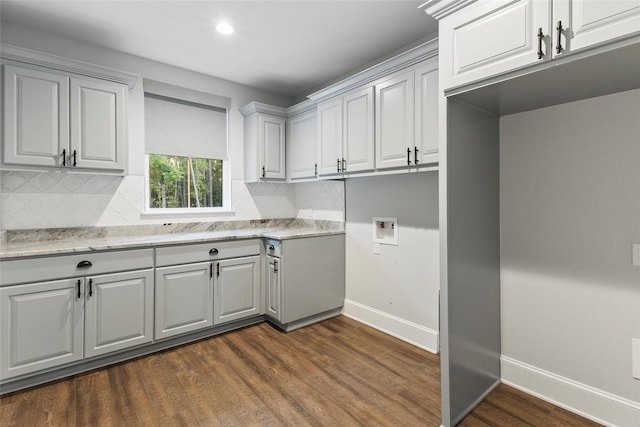 clothes washing area with hookup for a washing machine, cabinets, and dark hardwood / wood-style floors