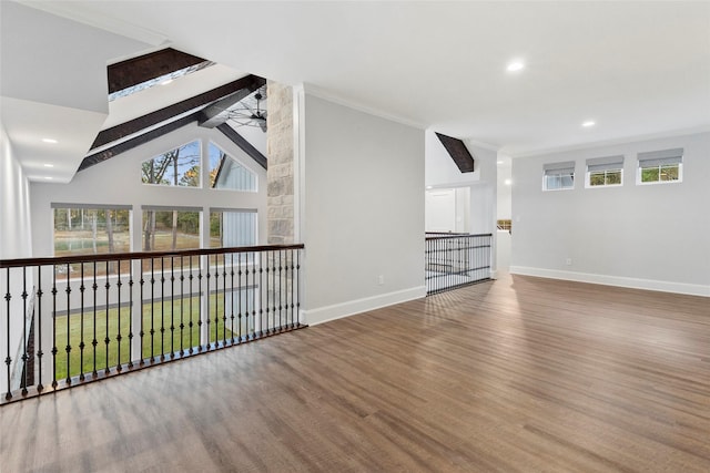 unfurnished living room featuring hardwood / wood-style floors, ceiling fan, ornamental molding, high vaulted ceiling, and beam ceiling