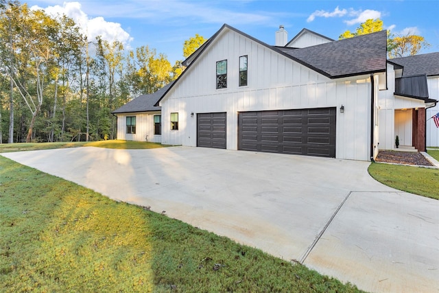 modern farmhouse with a front yard and a garage