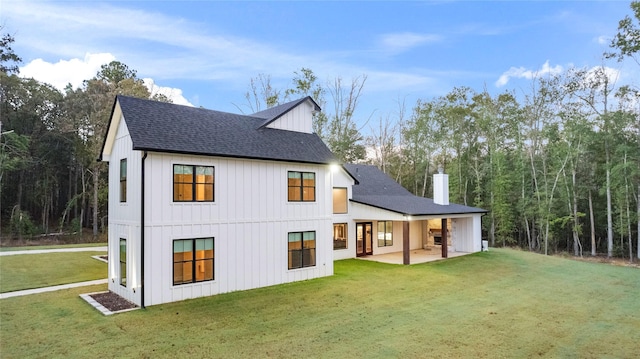 rear view of property with a yard and a patio area