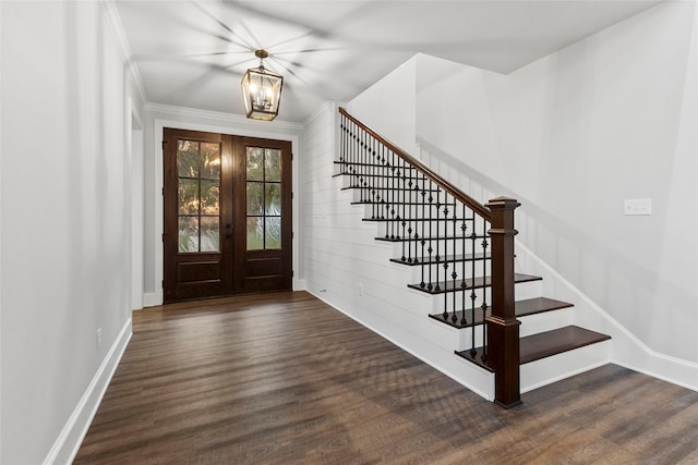 entrance foyer with a notable chandelier, french doors, ornamental molding, and dark hardwood / wood-style floors