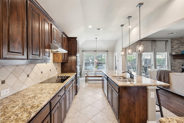 kitchen with sink, vaulted ceiling, decorative backsplash, hanging light fixtures, and black electric cooktop