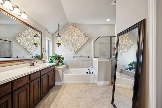 bathroom with tile patterned flooring, a tub to relax in, lofted ceiling, an inviting chandelier, and vanity