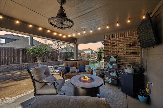 view of patio / terrace with ceiling fan and an outdoor living space with a fire pit