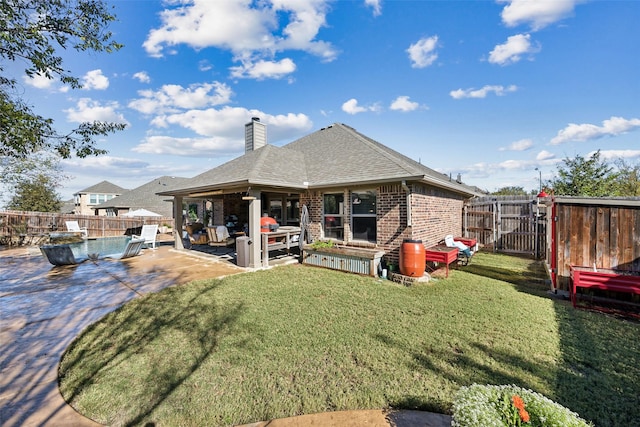 rear view of property with a lawn and a patio area