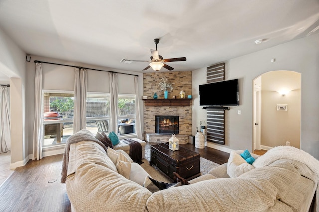 living room with a fireplace, ceiling fan, and hardwood / wood-style flooring