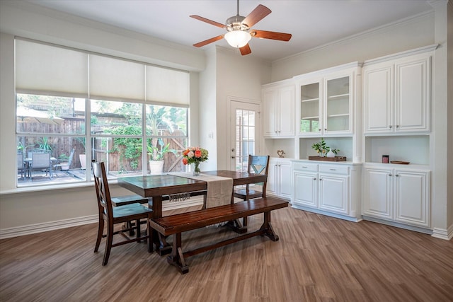 dining space featuring ceiling fan, ornamental molding, and light hardwood / wood-style flooring