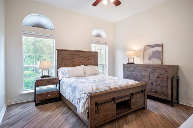 bedroom with multiple windows, ceiling fan, and light hardwood / wood-style floors