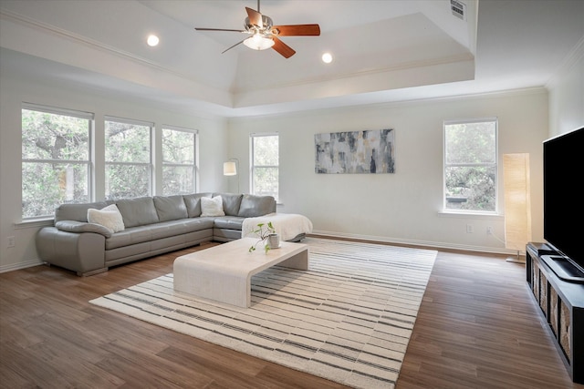 living room featuring ceiling fan, a tray ceiling, crown molding, and wood-type flooring