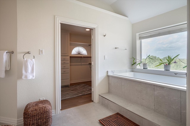 bathroom with vaulted ceiling and tiled tub