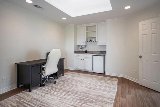 office area with crown molding, light hardwood / wood-style flooring, and sink