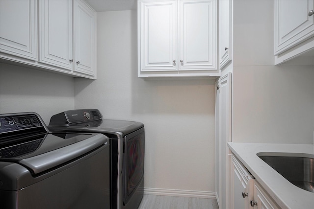 laundry room with sink, separate washer and dryer, and cabinets