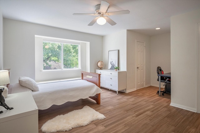 bedroom featuring hardwood / wood-style flooring, ceiling fan, and a closet