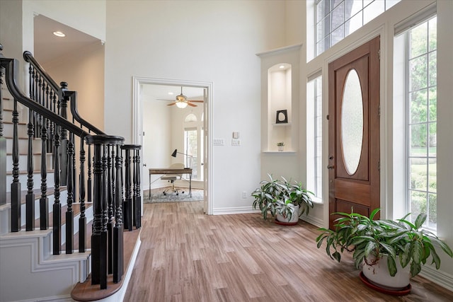 entrance foyer with a high ceiling, ceiling fan, and light hardwood / wood-style floors