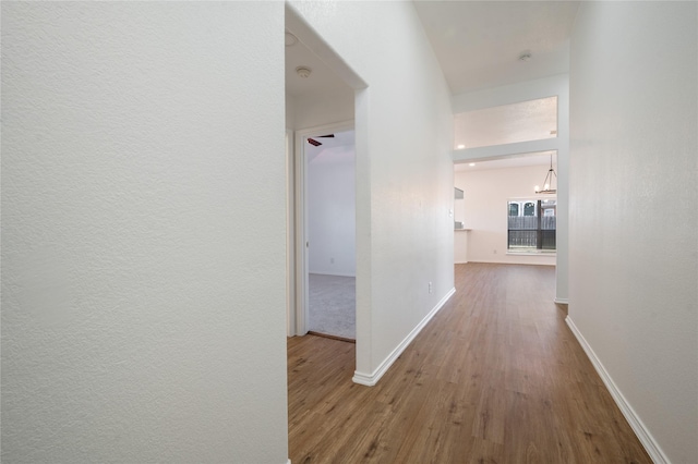 hall featuring a chandelier and hardwood / wood-style floors