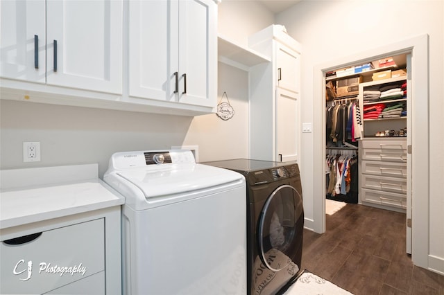 clothes washing area featuring washing machine and dryer, cabinets, and dark wood-type flooring