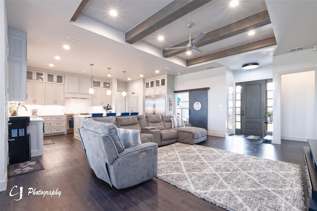 living room featuring ceiling fan, beamed ceiling, and dark hardwood / wood-style floors