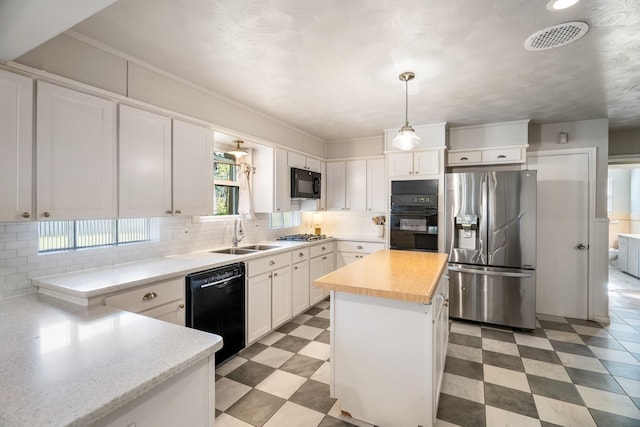 kitchen with decorative light fixtures, sink, white cabinetry, and black appliances