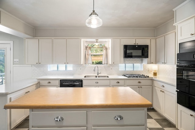 kitchen featuring white cabinetry, sink, a center island, and black appliances