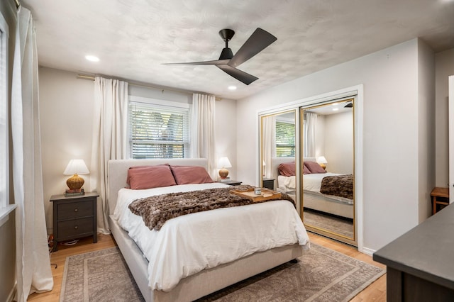 bedroom with ceiling fan, light hardwood / wood-style flooring, and a closet