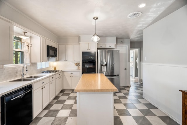 kitchen featuring a center island, hanging light fixtures, black appliances, white cabinets, and sink