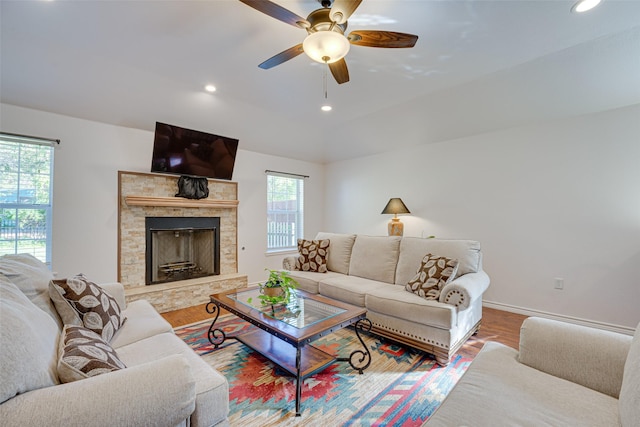 living room featuring vaulted ceiling, a fireplace, ceiling fan, and hardwood / wood-style flooring