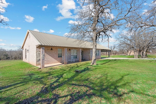 back of house featuring ceiling fan, a patio, and a lawn