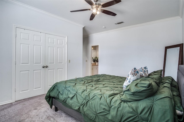 bedroom with ceiling fan, ornamental molding, a closet, and carpet