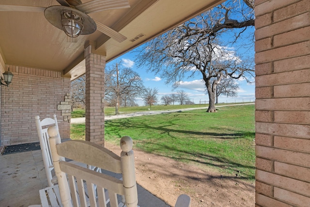 view of yard with ceiling fan and a patio