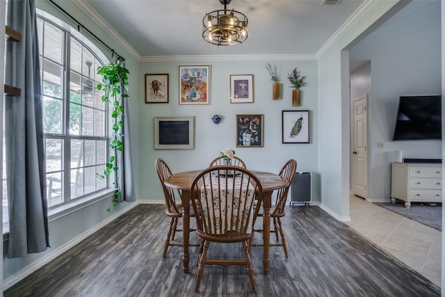 dining area with tile patterned flooring, a chandelier, and ornamental molding