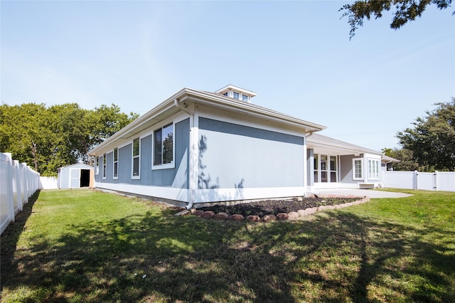 back of property featuring a yard and a storage unit