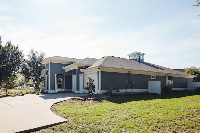 view of property exterior featuring central AC unit, a yard, and a garage