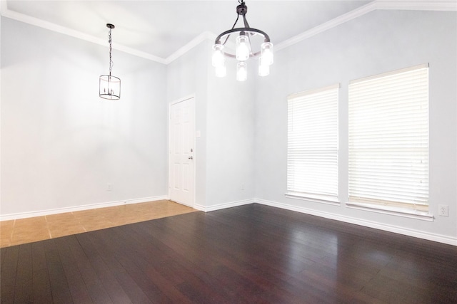 empty room featuring ornamental molding, a notable chandelier, and hardwood / wood-style floors