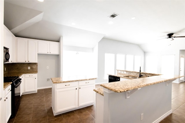 kitchen featuring an island with sink, light stone countertops, black appliances, and white cabinetry