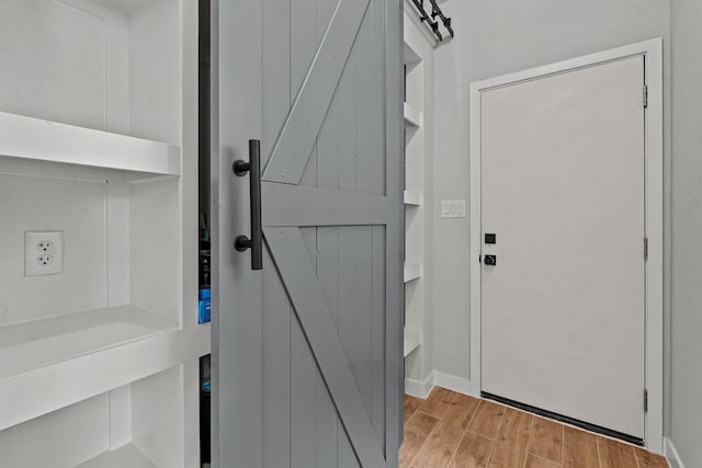 interior space featuring a barn door, baseboards, and wood finish floors