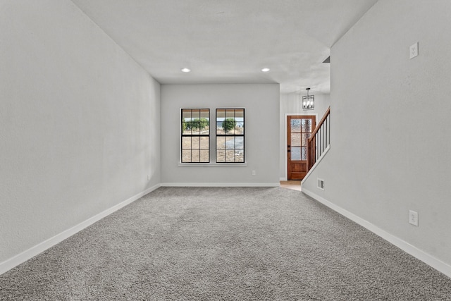 spare room with a chandelier, recessed lighting, baseboards, stairway, and carpet