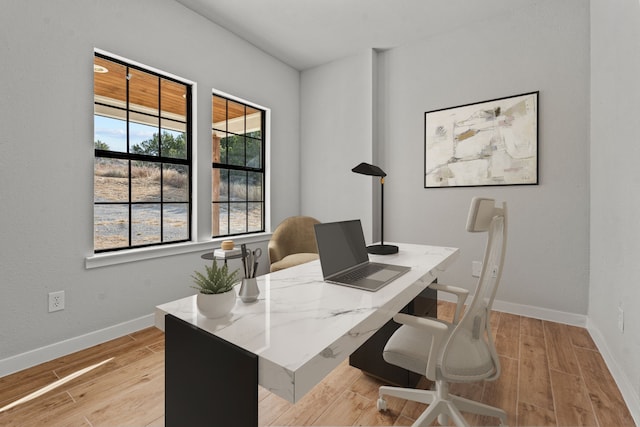 office area with light wood-style flooring and baseboards