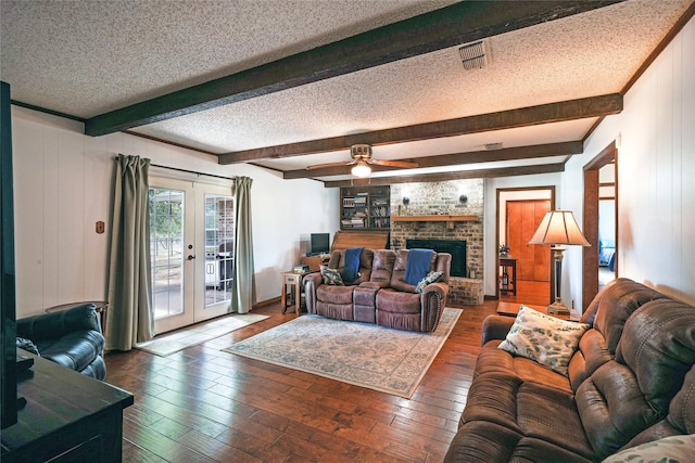 living room with ceiling fan, french doors, dark hardwood / wood-style floors, beam ceiling, and a textured ceiling