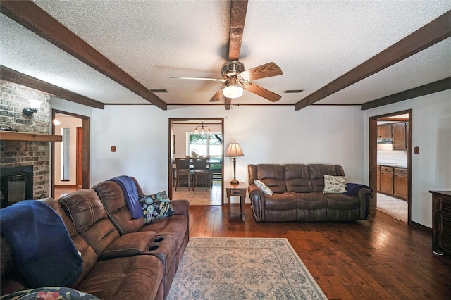 living room with a textured ceiling, dark hardwood / wood-style flooring, and ceiling fan