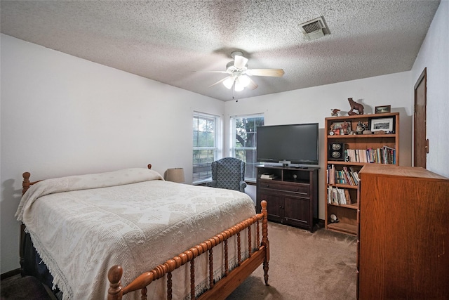 bedroom with carpet floors, ceiling fan, and a textured ceiling