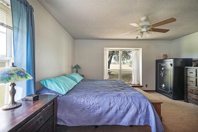 bedroom with ceiling fan, light carpet, and a textured ceiling