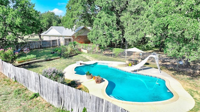 view of pool featuring a lawn, a water slide, and a diving board