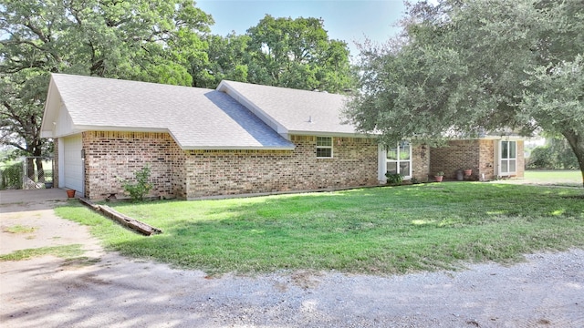 ranch-style home featuring a garage and a front lawn