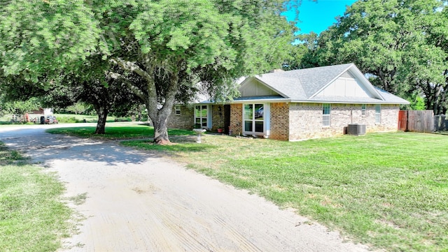 view of front of property with cooling unit and a front yard